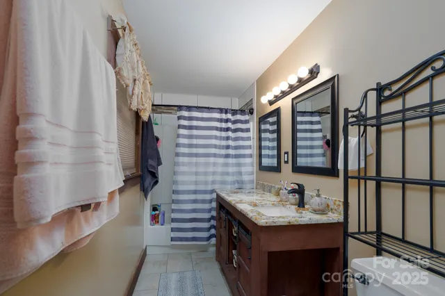 a bathroom with a granite countertop sink toilet and shower