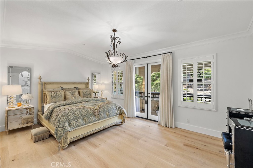 28 Tuscany Ladera Ranch, CA 92694 - Photo 21 of 47 a spacious bedroom with a bed a chandelier and a window
