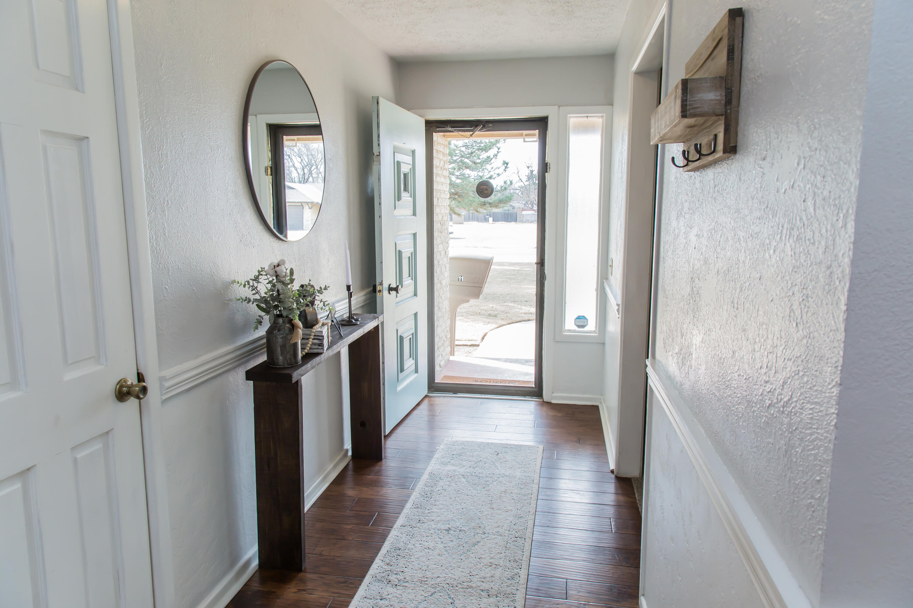 1106 Amarillo Plainview, TX 79072 - Photo 5 of 61 a view of a hallway with wooden floor and a chandelier