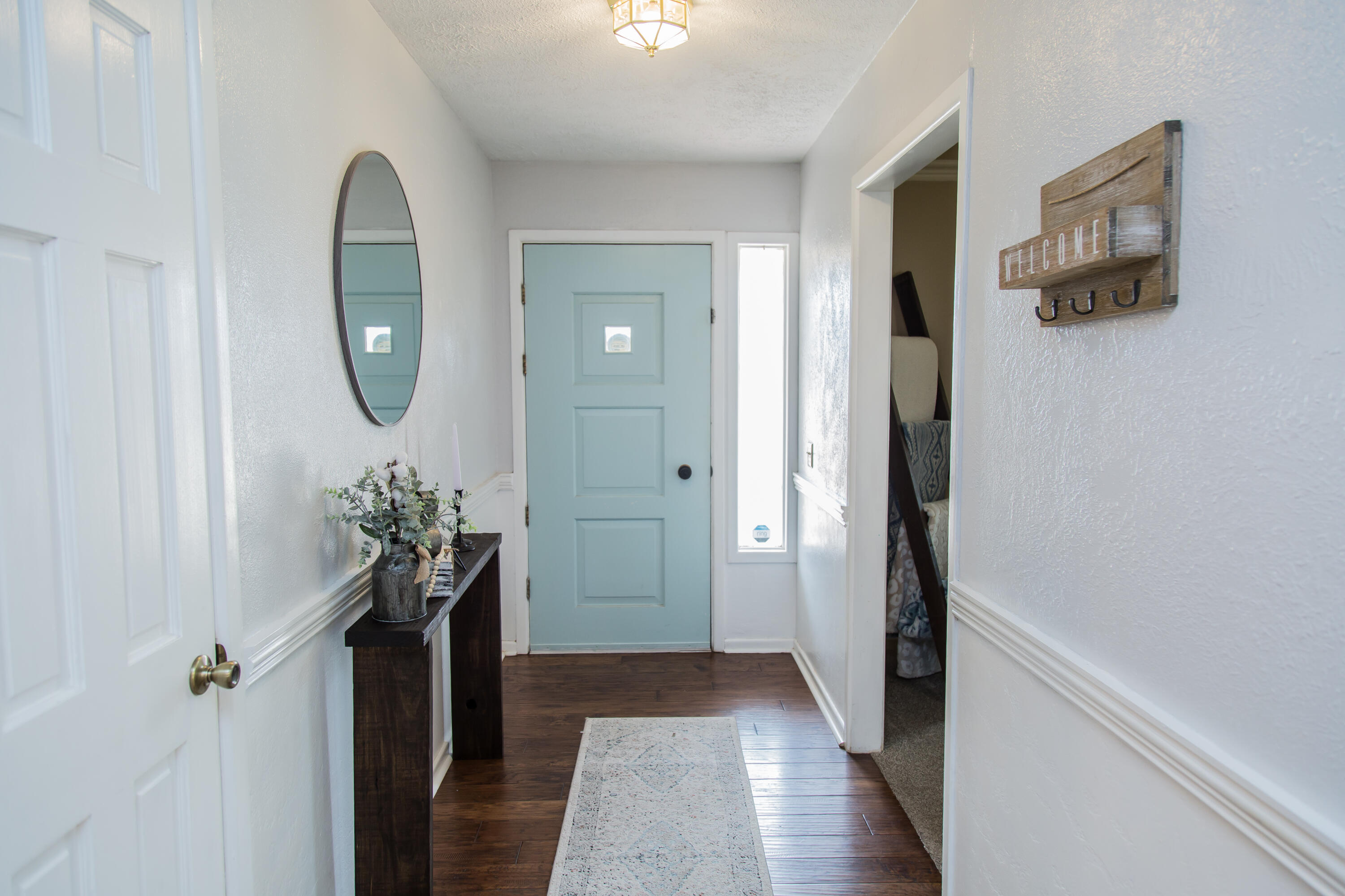 1106 Amarillo Plainview, TX 79072 - Photo 6 of 61 a view of a hallway with wooden floor and a chandelier