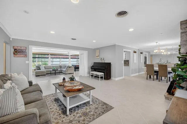 a living room with furniture and a view of kitchen