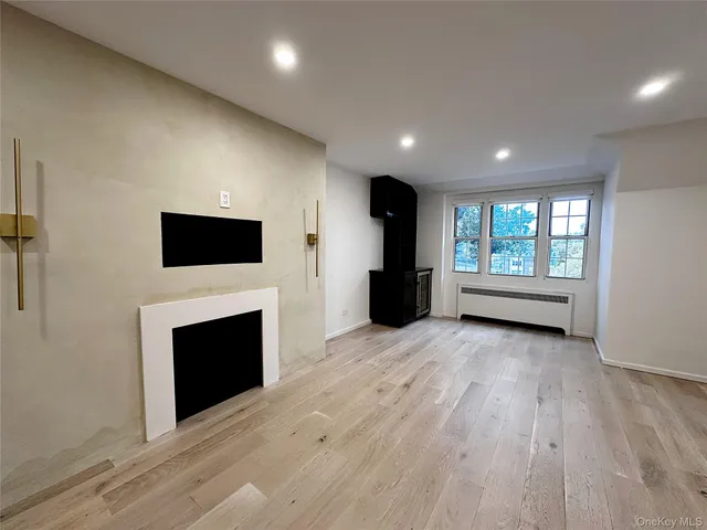 a view of empty room with a fireplace and wooden floor