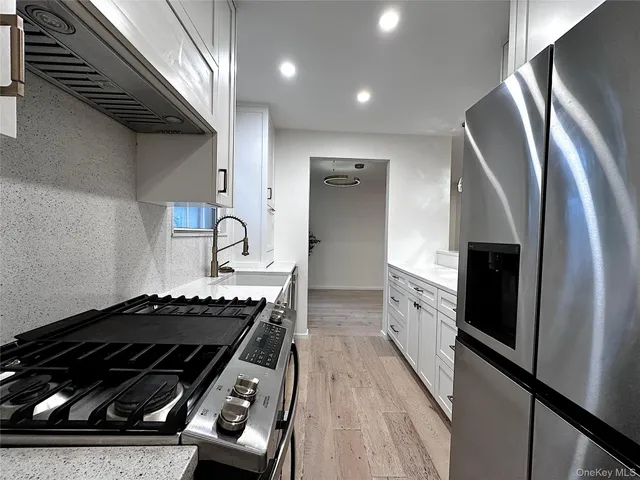 a kitchen with granite countertop a stove and a refrigerator