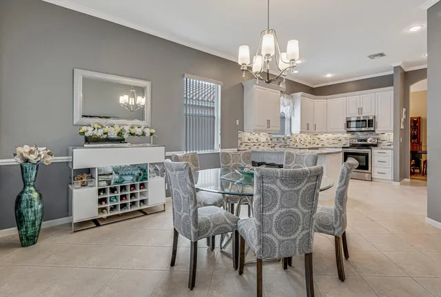 a dining room with furniture a chandelier and window