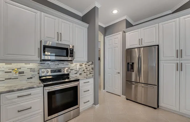 a kitchen with white cabinets and stainless steel appliances
