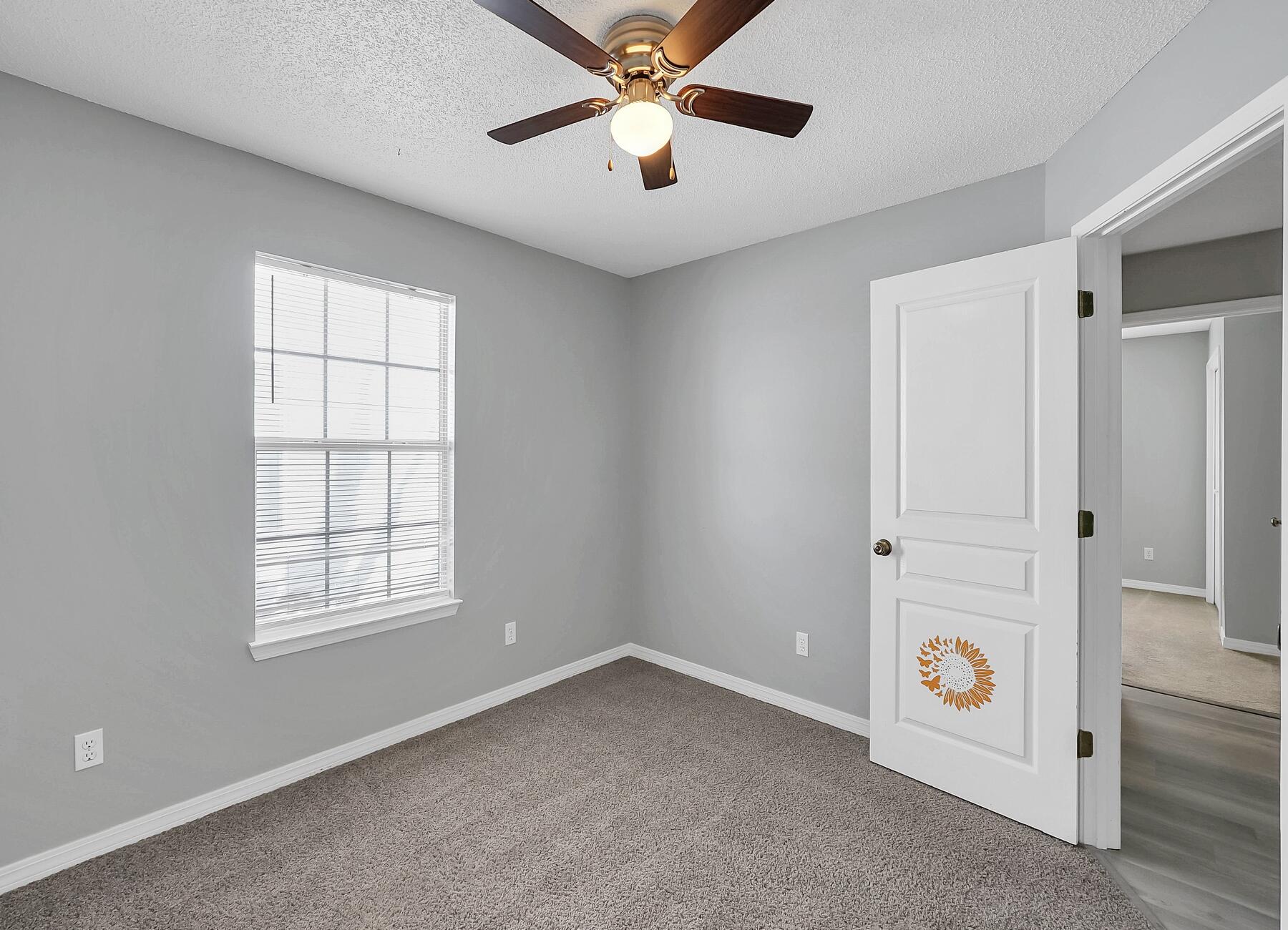 129 Wright Circle Niceville, FL 32578 - Photo 16 of 44 an empty room with windows and chandelier fan