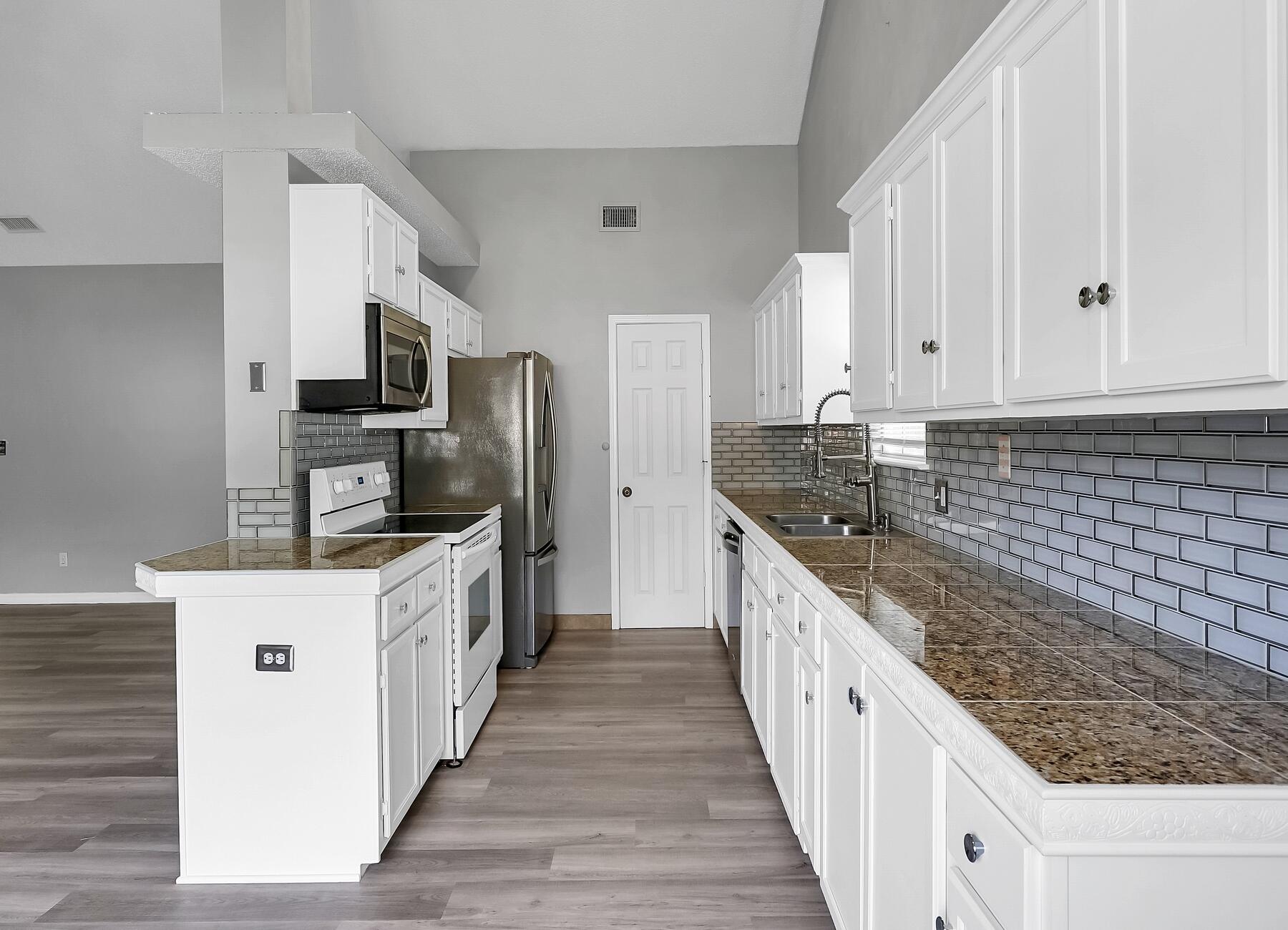 129 Wright Circle Niceville, FL 32578 - Photo 19 of 44 a kitchen with stainless steel appliances granite countertop a stove top oven a sink dishwasher and a refrigerator