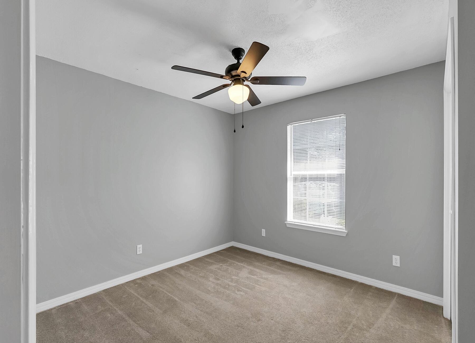 129 Wright Circle Niceville, FL 32578 - Photo 23 of 44 an empty room with windows and fan