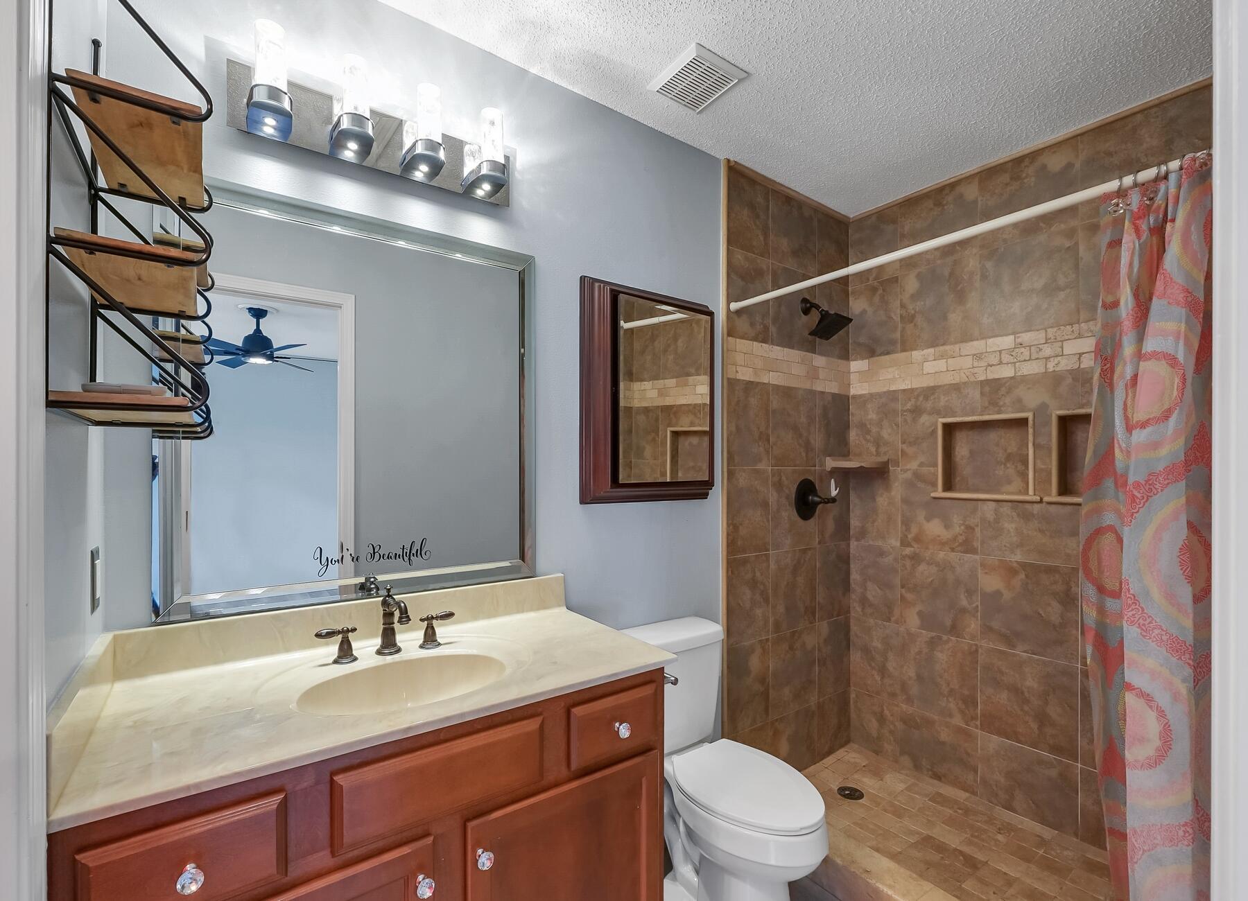 129 Wright Circle Niceville, FL 32578 - Photo 28 of 44 a bathroom with a granite countertop sink a toilet a mirror a vanity and shower