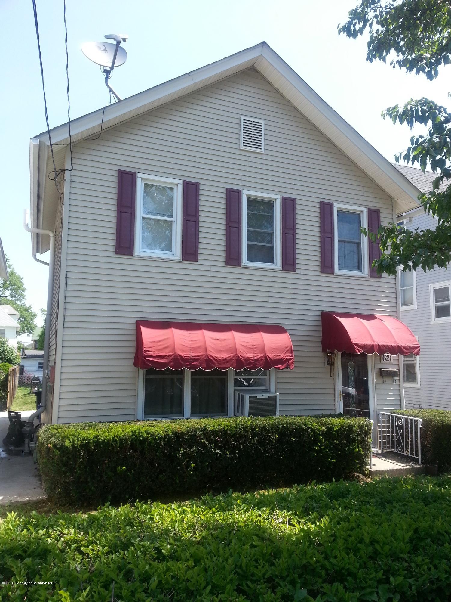 a front view of a house with a yard and outdoor seating
