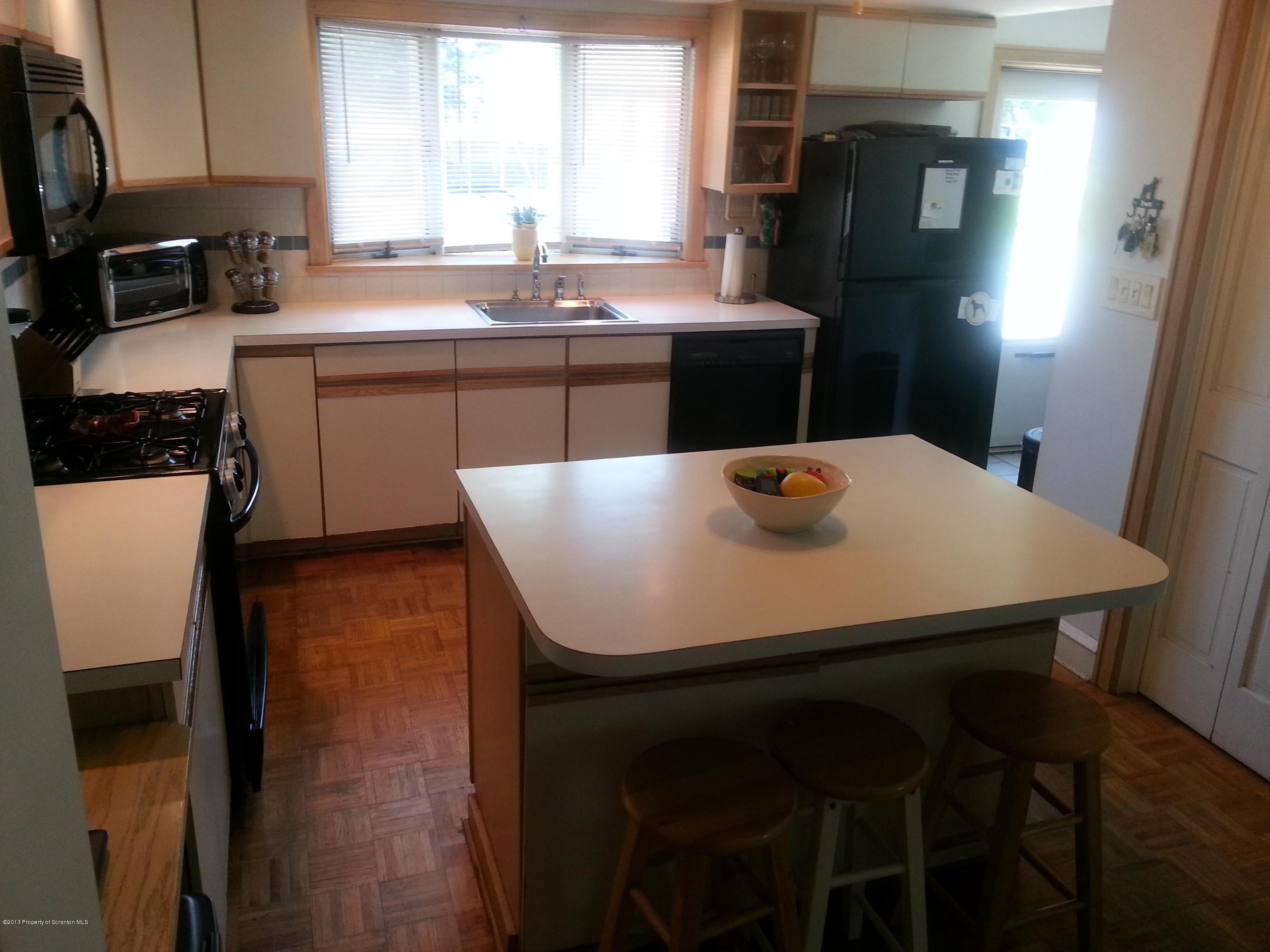 621 Electric Street Scranton, PA 18509 - Photo 13 of 29 a kitchen with a table chairs and refrigerator