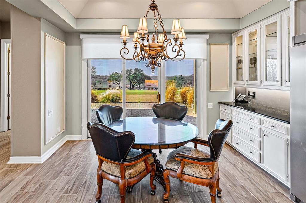 8908 Brierfield Road Granbury, TX 76049 - Photo 16 of 40 a view of a dining room with furniture a chandelier and wooden floor
