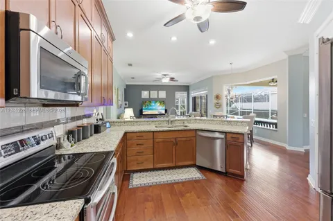 a kitchen with stainless steel appliances granite countertop a sink stove and refrigerator