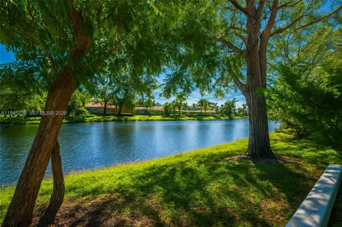a front view of a house with a garden and trees
