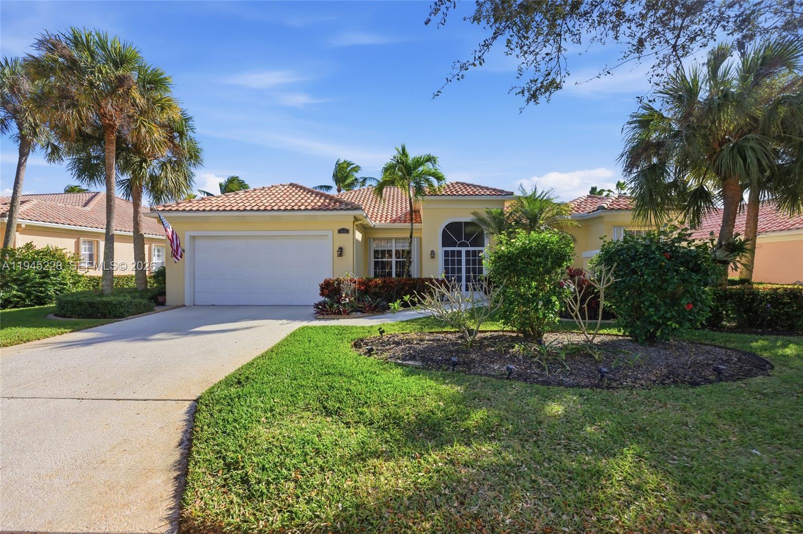 7646 Red River Road West Palm Beach, FL 33411 - Photo 4 of 69 a front view of a house with a garden and trees