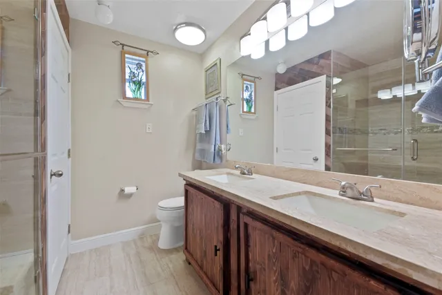 a bathroom with a granite countertop sink a toilet and a mirror
