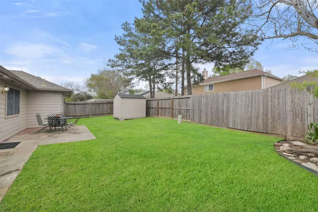 a view of a backyard with table and chairs and wooden fence