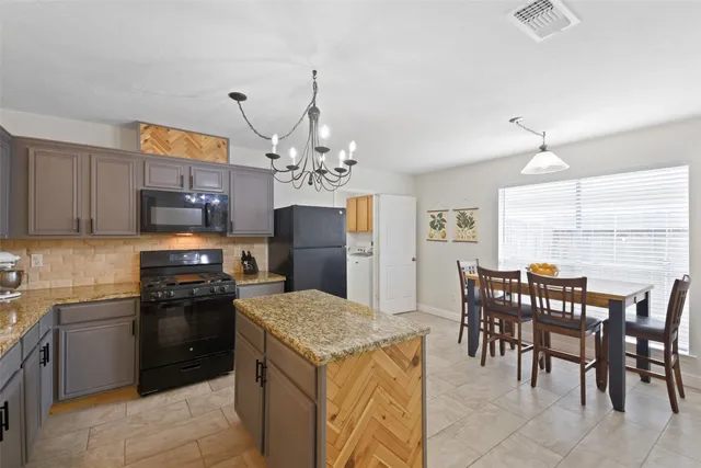 a kitchen with kitchen island granite countertop a sink counter and chairs