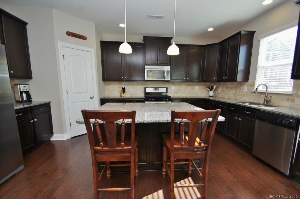 2001 Fallondale Road, Unit 919 Waxhaw, NC 28173 - Photo 7 of 24 a kitchen with stainless steel appliances granite countertop a sink a stove a table and chairs