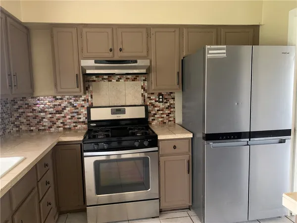 a stove top oven sitting inside of a kitchen