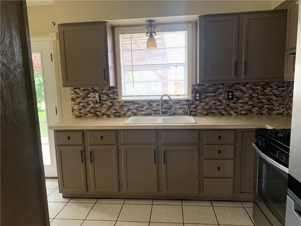 a kitchen with granite countertop white cabinets and window