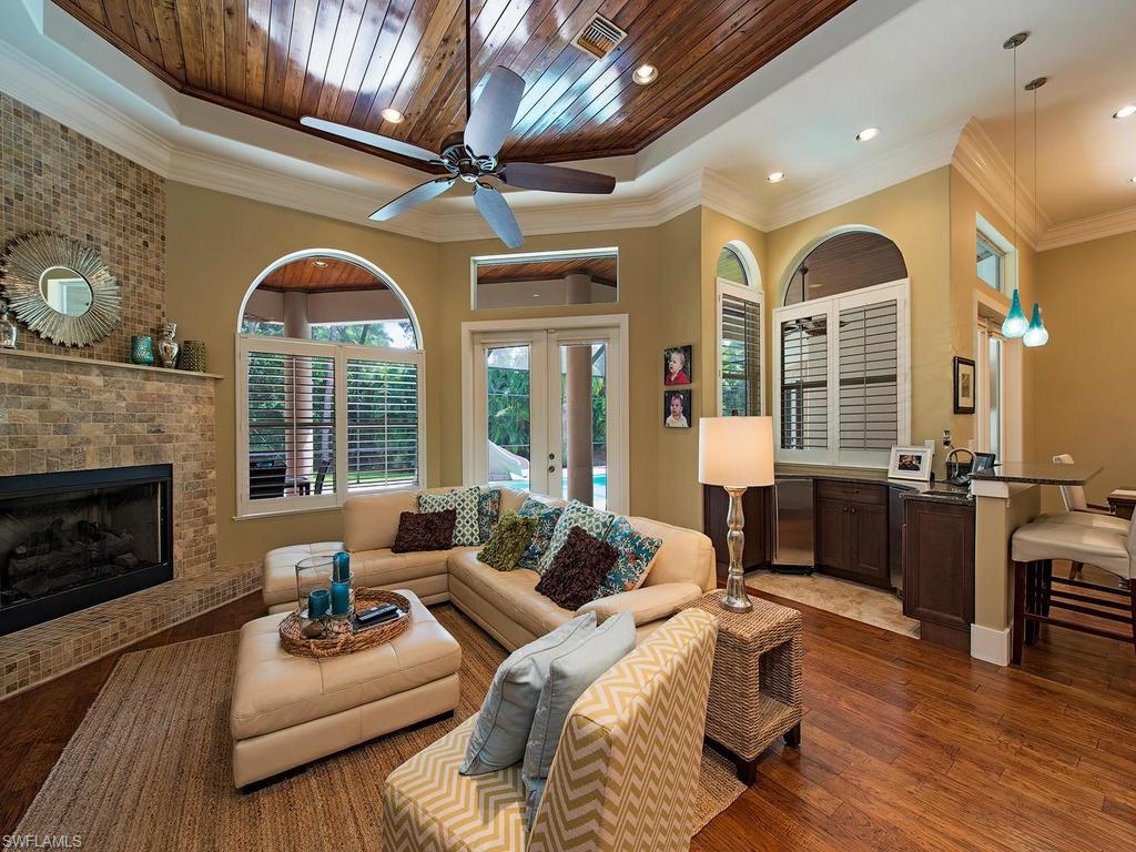 59 Myrtle Road Naples, FL 34108 - Photo 3 of 25 Great room lounge space with fireplace and bar with ice maker and fridge
