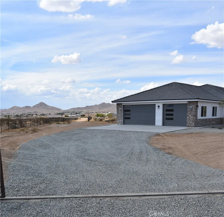 16944 Pauhaska Road Apple Valley, CA 92308 - Photo 13 of 74 a view of a house with a yard and a large tree