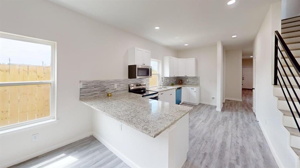 6702 South Lancaster Road Dallas, TX 75241 - Photo 3 of 20 Modern kitchen featuring white cabinetry, light-toned countertops, a tile backsplash, and stainless steel appliances