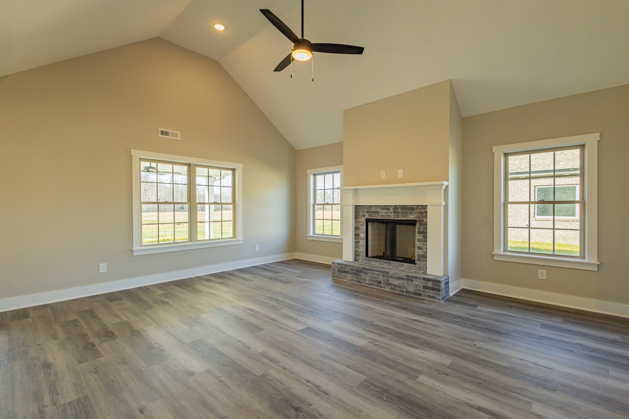 58 Brooklyn Avenue Manchester, TN 37355 - Photo 22 of 62 an empty room with wooden floor fireplace and windows