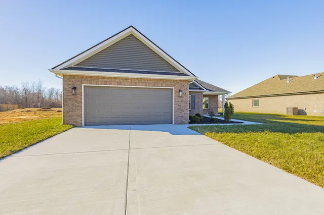 an empty room with wooden floor fireplace and windows
