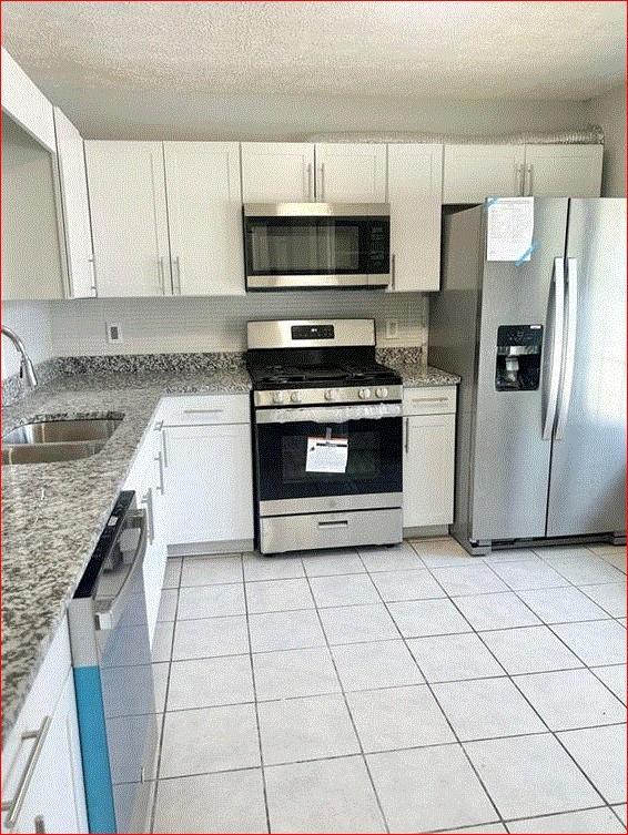 1021 Thorn Woode Lane Stone Mountain, GA 30083 - Photo 3 of 6 a kitchen with cabinets a sink and stainless steel appliances
