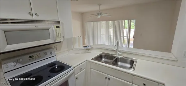 a kitchen with a stove a sink and cabinets