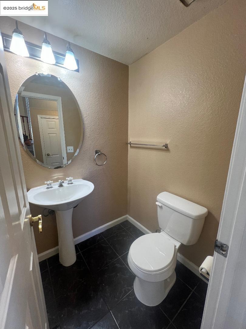 5016 Perry Way Antioch, CA 94531 - Photo 4 of 16 a bathroom with a toilet sink and mirror