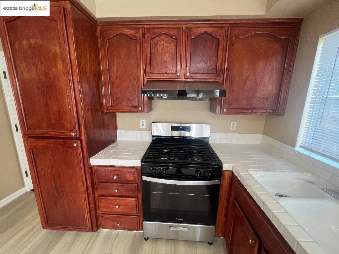 5016 Perry Way Antioch, CA 94531 - Photo 6 of 16 a kitchen with granite countertop wood cabinets and a stove top oven