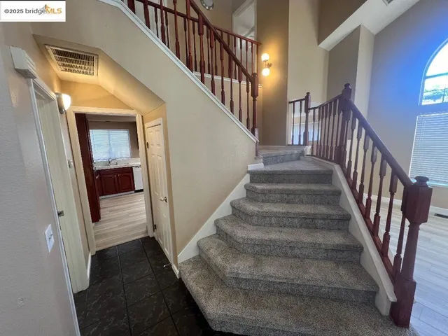 a view of staircase with wooden floor and a chandelier
