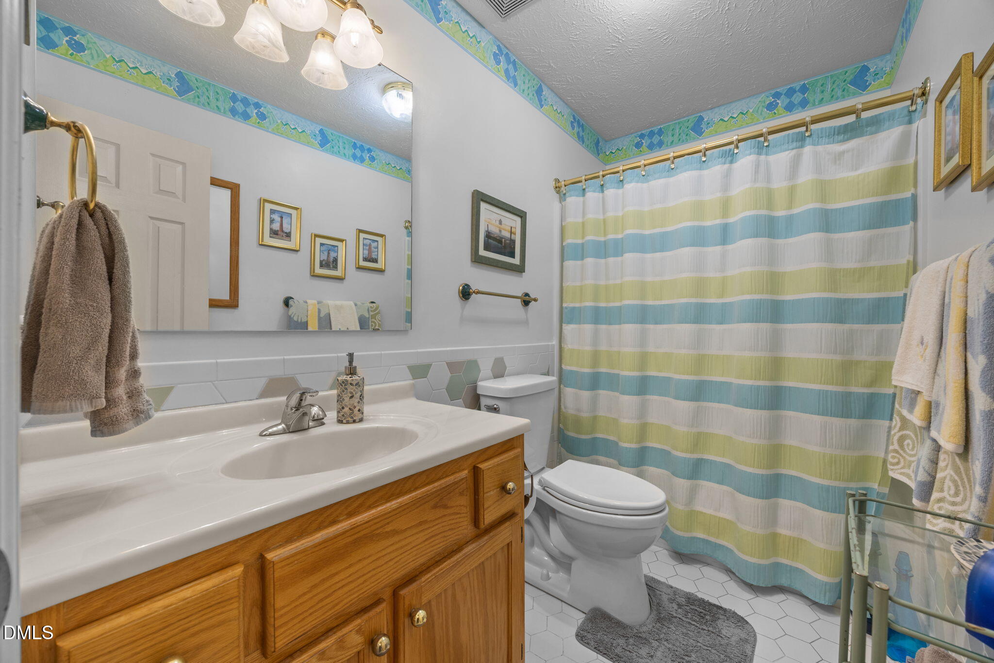 69 Deer Run Court Angier, NC 27501 - Photo 21 of 40 a bathroom with a sink a toilet a mirror and shower curtain