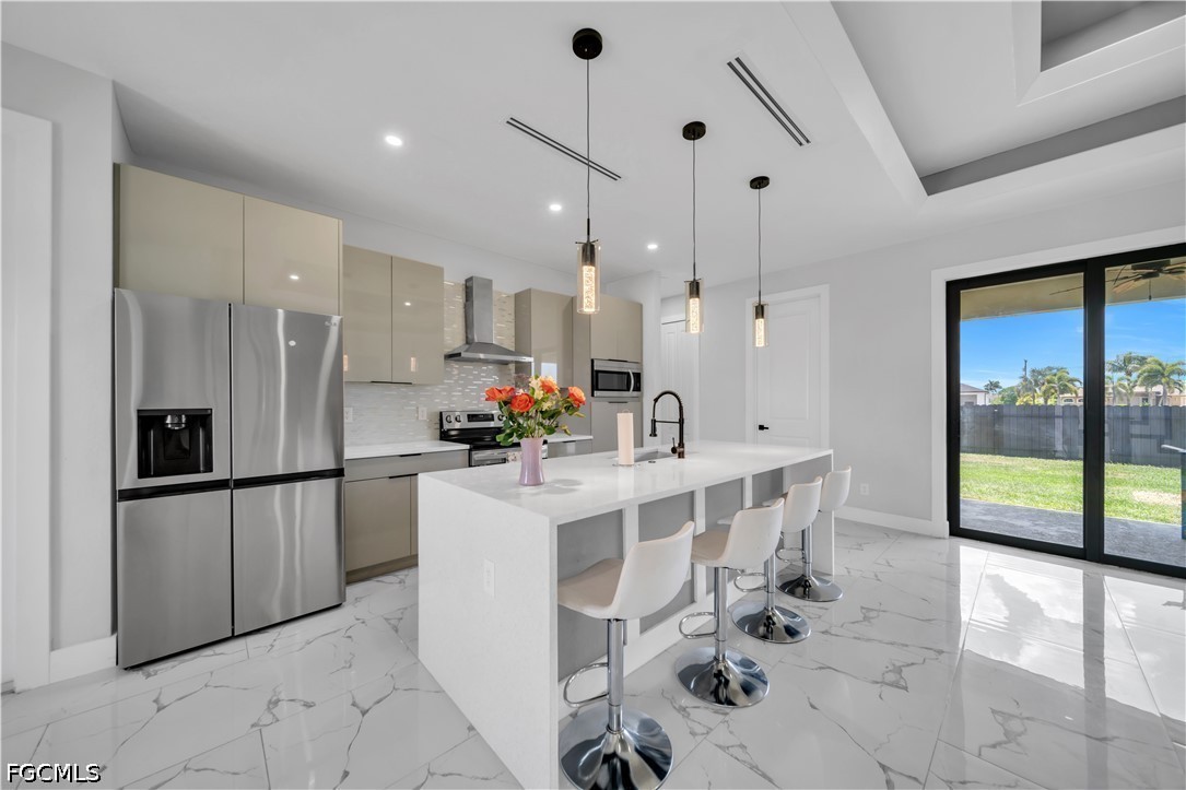 1128 Nelson Road North Cape Coral, FL 33993 - Photo 6 of 22 a kitchen with stainless steel appliances kitchen island granite countertop a refrigerator and a sink