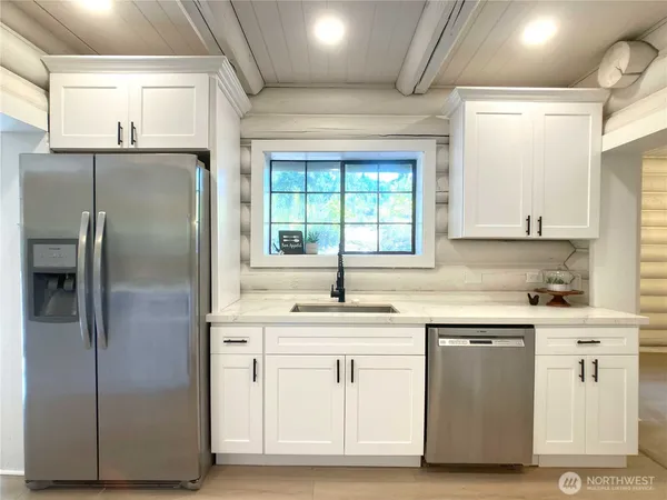 a kitchen with white cabinets and white stainless steel appliances