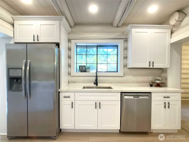 a kitchen with white cabinets and white stainless steel appliances