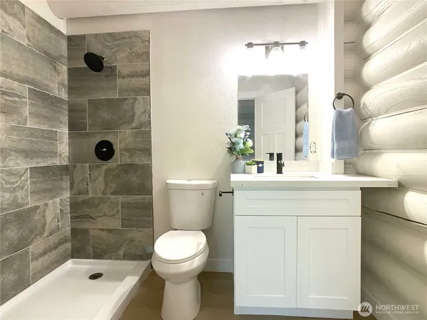 a bathroom with a sink a toilet and shower