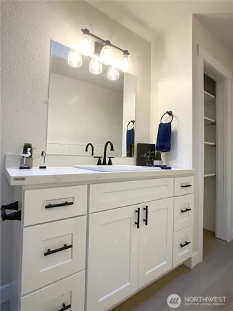 a bathroom with a sink vanity and mirror