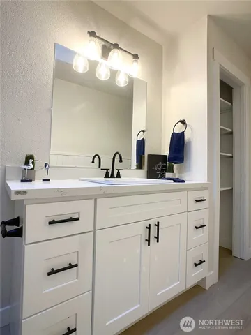a bathroom with a sink vanity and mirror
