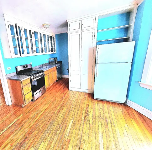 a kitchen with granite countertop a refrigerator and a stove top oven