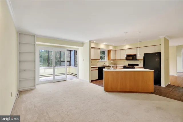 a large room with kitchen view and stainless steel appliances
