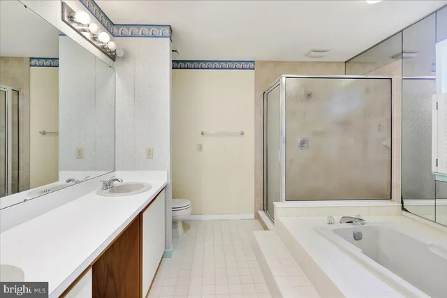 a bathroom with a tub a sink a mirror and a shower
