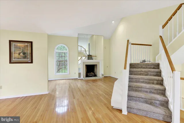 a view of a hallway with wooden floor and a fireplace