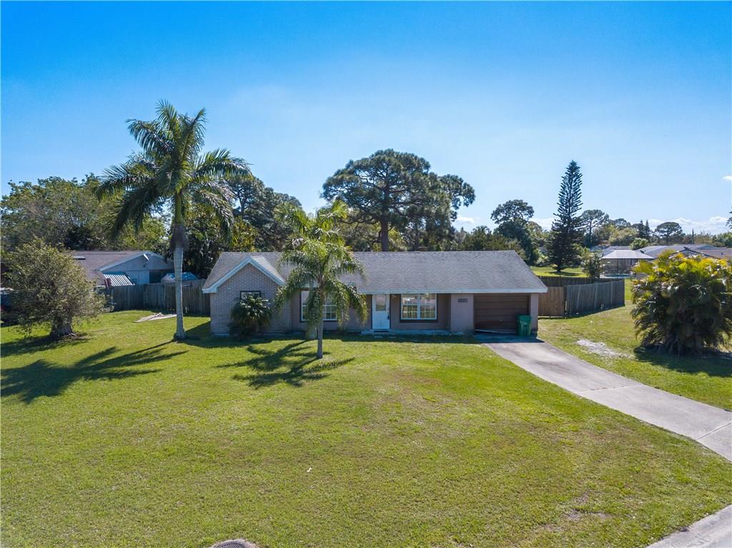 2079 Southeast Triumph Road Port St. Lucie, FL 34952 - Photo 1 of 23 a swimming pool with some tall trees in the background