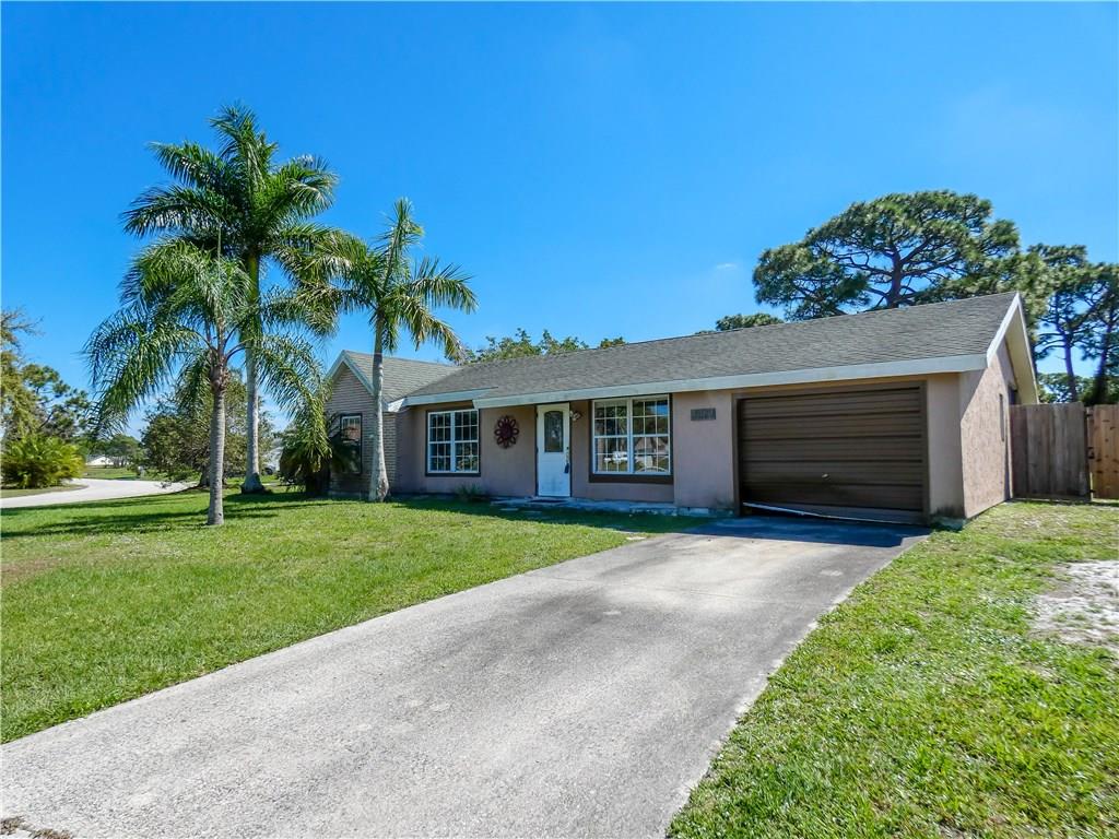 2079 Southeast Triumph Road Port St. Lucie, FL 34952 - Photo 15 of 23 a front view of a house with a garden and trees