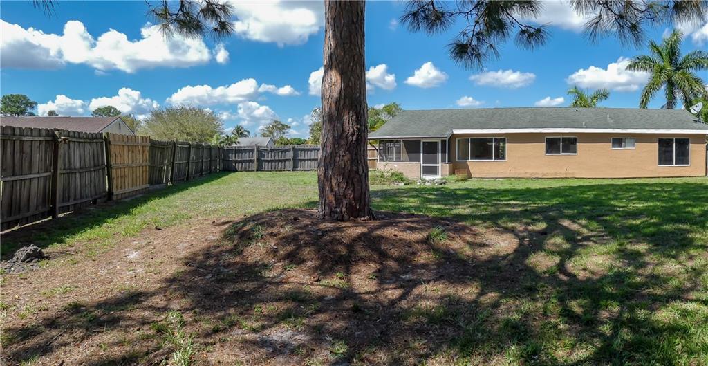 2079 Southeast Triumph Road Port St. Lucie, FL 34952 - Photo 22 of 23 a view of a house with backyard and a tree