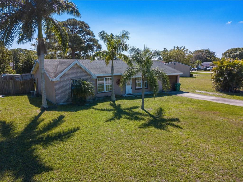 2079 Southeast Triumph Road Port St. Lucie, FL 34952 - Photo 23 of 23 a view of a house with swimming pool and a yard